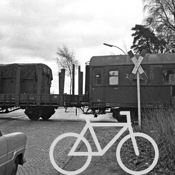 Das Bild zeigt einen historischen Bahnübergang. Heutzutage findet auf dem Bahnradweg in der Nähe von Bad Oldesloe ein Krimi-Trail auf dem Fahrrad statt
